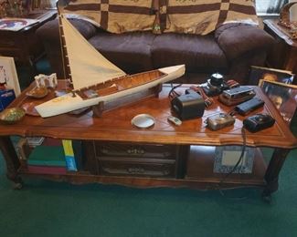 Coffee table (part of a matching set one of four), small hand-carved sail boat (Kenneth Floyd), camera collection, vintage games, and more. 