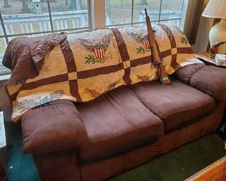Love seat, quilt, carved wooden toy rifle (bolt-action). 