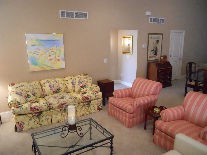 Living Room:  An original piece of art by artist MICHAELS hangs above a quality CENTURY brand floral sofa.  To the right are separately priced CENTURY brand occasional chairs in a raspberry/yellow stripe upholstery.  Also shown is a wine cellarette [in the corner] and a heavy iron coffee table with glass top and an iron/glass candleholder.  Some closer photos follow.  