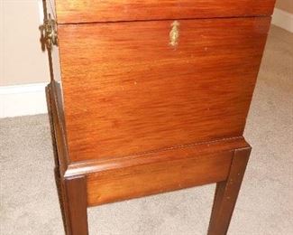 Living Room:  A vintage mahogany wine cellarette is on an attached stand and has brass carrying handles.  A photo of the interior follows.  (The key will be with the cashier.)