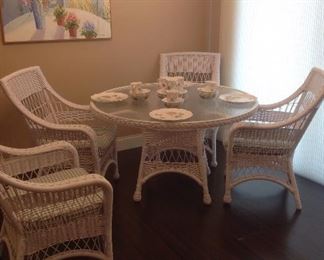 Kitchen:  A beautiful LANE WeatherMaster All-Natural Indoor/Outdoor table with glass top and four arm chairs with chair cushions is near an original piece of art (shown in next photo).  This set is in excellent condition.   The chair was pulled to the side so you could see the table's base.  The table is set with LENOX Butterfly Meadow-Dragonfly china.