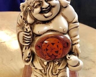 c.1970, "LUCKY BUDDHA" with clear resin front belly, back, and underneath on bottom. Each of the resin pieces contain lucky "charms," such as Chinese coins, horseshoes, etc. (6-1/2" tall)