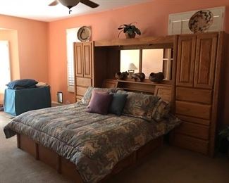 Custom made by Woodley's of CO. King size bed with side storage and under-bed storage. Mirrored headboard. Comes with pillows and bedspread.