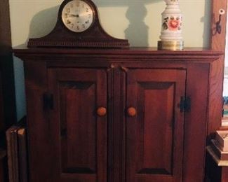 Cabinet with antique clock and vintage lamp