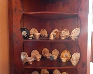 Corner cabinet with several tea cups.