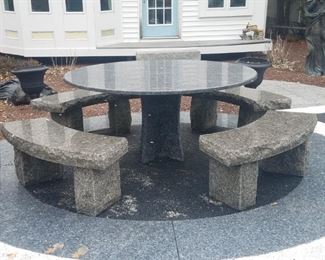 Large round granite table with curved benches 