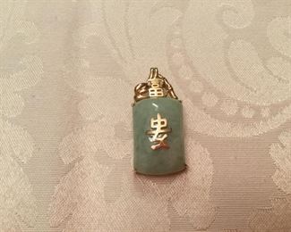 Jade pendant light green with Chinese’s writing in gold 14kt gold & bail. 2”T