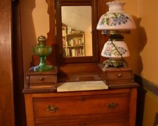 Antique Cherrywood Marble Topped and Mirrored Dresser featuring 3 Drawer Chest with 2 Glove Boxes on each side of Marble Top.  Don't overlook the rare Aladdin Lamp on the left nor the Beautiful Handpainted Milk Glass and Brass Lamp on the right side of the Dresser