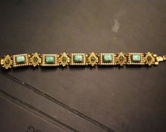 This appears to be a Southwestern Gold Bracelet with Turquoise Stones, Seed Pearls and Emerald (we are awaiting the appraisal for this item)