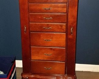 Cherry finish jewelry armoire. Has tons of storage. Top pops up to expose a mirror