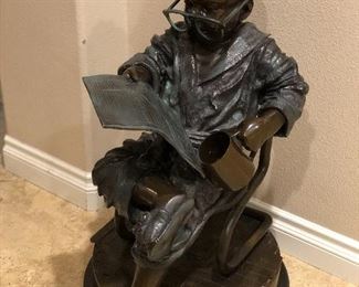 Bronze boy reading newspaper signed by Jim Davidson 
