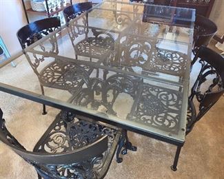 Glass top wrought iron table and six wrought iron chairs