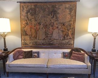 Mid-century modern sofa, lamps, and large tapestry