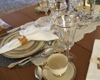 Table with the gold and silver tableware and beautiful crystal stemware.