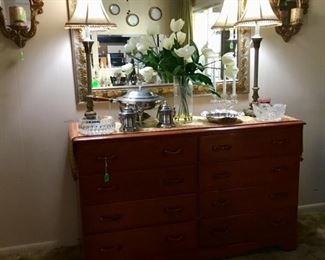 The chest in dining room used as a buffet with lots of drawers.  Big gold mirror above with buffet lamps.