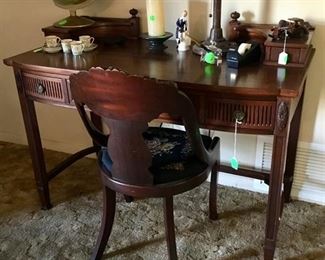 A beautiful mahogany desk with beautiful carving, drawers with a small stand on each side.  The size of the desk is wonderful.