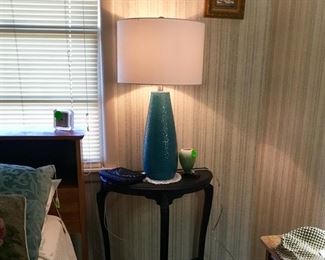 Black end table with blue lamp.