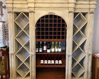 Stunning wine display cabinet. Distressed ivory finish with dark wood shelves in the center. Purchased from Architectural Warehouse. Has a Habersham look. 