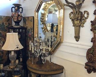 Pair of octagonal giltwood Italian mirrors, opposing pair of 18th century demilune consoles with figural putti, pair of oversized bronze sconces