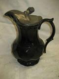 POTTERY PITCHER WITH PEWTER LID, 8 1/2 INCHES TALL, CALLED A JACK FIELD ? BLUE INSIDE AND BLACK OUTSIDE FINISH ,