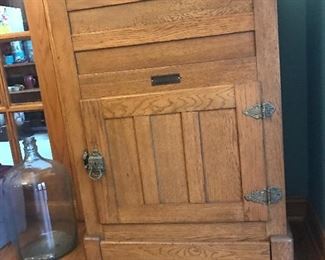 Antique oak icebox with metal interior ready to be used as a bar cart .