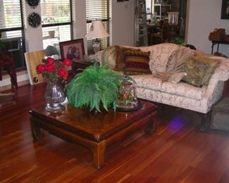 Camelback sofa with Oriental-style coffee table and matching side table.