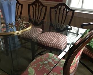 Glass table with upholstered chairs.