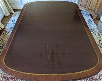 Banded mahogany dining room table by Henkle-Harris, Winchester, VA. Beautiful condition, with two large leaves, table pads original storage sleeves and boxes.