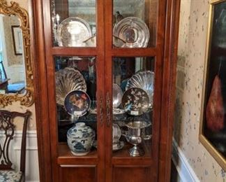 One of the pair of Century Furniture lighted china cabinets, with beveled glass door and side lights.