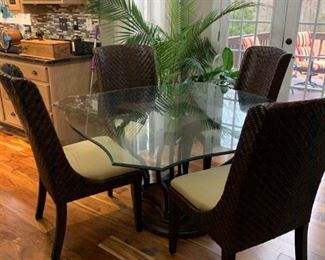 Lovely glass topped dining table with 4 wicker like chairs. 