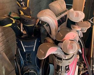 Two sets of golf clubs, men’s and women’s, right handed. 