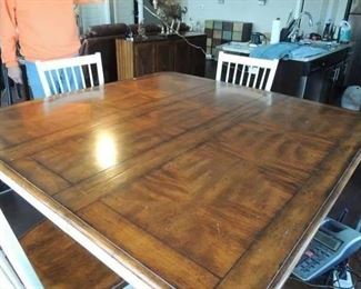 .Very nice Counter high dining table at 30" high. It has a 14" removeable leaf that make it 54" X 54" or 54" X 40" without it. Comes with 4 matching chairs and can seat 8. There ars 2 storage drawers in the base,
