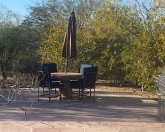Round cement patio table, umbrella and 4- Bruce Eicher Iron chairs with pads. $800