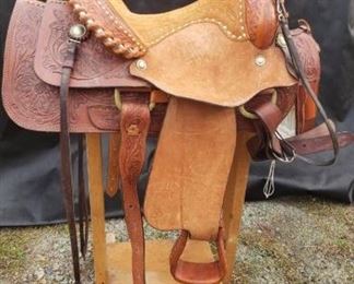 Hand tooled two rig Simco saddle with white lacing and metal work. https://ctbids.com/#!/description/share/314366