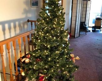 Unique lit Christmas tree with festive figures below 