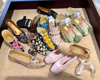 Collection of miniature shoes, some individual and some pairs
