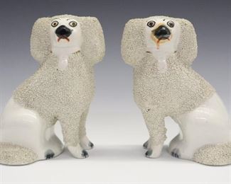 A pair of late 19th century Staffordshire dogs. Molded Poodles with open fore legs, confetti coats and painted detail. Wear and overall crazing, paint on muzzles varies slightly. Each 5 1/2" high.