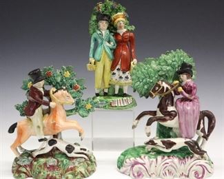 Three 19th century Staffordshire figures. Two depict a woman and a man on horseback, the third with a couple beneath an arbor. All with bocages, molded bodies with polychrome decoration. All with minor damage and/or repairs to bocages, the woman's horse has a repaired tail and forelegs, the man's has a repaired foreleg. Up to 7 3/4" high.