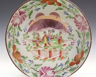 An early 19th century English Pearlware punch bowl. Pink lustre design with enameled floral decoration and an Eastern Garden scene in the bowl. Wear, crazing and minor loss to the enamel. 10 1/2" diameter x 5" high.