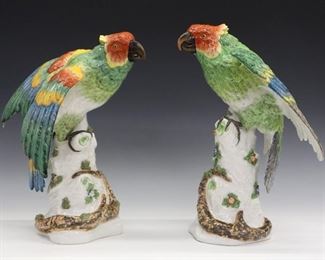 Two Late 19th Century French Porcelain Parrots. Similarly designed porcelain figures of parrots, both with brightly colored feathers, perched on tree trunks that are clad with flowers, leaves, and vines. Each with crossed arrows in blue under glaze (Bloch/Bourgeois Factory, Paris), one with retailer's mark "Ovington New York, France" in red, over glaze. Some chipping to leafy and floral motif, one with small chip to tip of beak, light wear to painted decoration. 8 1/4 x 14 5/8" high.