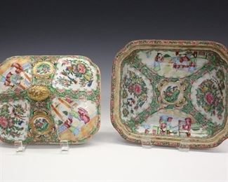 A Chinese "Rose Medallion" Porcelain Covered Dish. Rectangular form with canted corners covered dish consists of a gilt finial at the cover which is decorated, along with the interior, with alternating vignettes enclosing figures or birds and butterflies with blossoming branches, on a green scroll and pink floral ground. Unmarked. Light wear to the decoration, small flake to the rim of the dish and small repair to foot rim. 9 1/4 x 8 x 6" high.