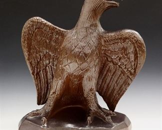 A Late 19th to Early 20th Century Ceramic Sculpture of an Eagle. Depicts an Eagle with its wings spread open, covered with a brown glaze overall. Possibly an architectural or roof ornament. Firing cracks at the neck and chest. 19 x 10 1/2 x 22 1/2" high.