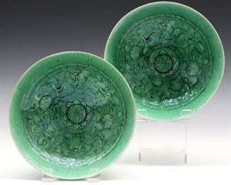 Two Late 19th Century Chinese Porcelain Bowls. Light weight porcelain round bowls of tapered form with raised molded pattern at the interior, including a Greek key pattern, Chinese characters, scrolling motifs, dragons and exotic birds all under a rich emerald green glaze. Unmarked. One with a flake at the interior, the other with small repair and chip at the rim. 8 diameter.