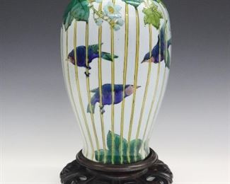 A Japanese Kutani Porcelain Vase. Enamel decorated vase with bluebird, blossom, and leaf motif contained within a bamboo fence about the whole. Fuku mark at the underside. Some crazing overall. 9 3/4" high.