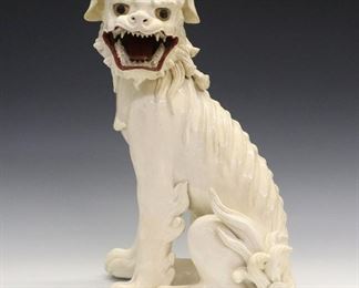 A 19th Century Chinese Edo Period Glazed Ceramic Figure of a Shishi. Kyoto ware figure of a seated Shishi, or Foo Dog, with white crackle glaze overall is depicted with gilt eyes and mouth agape, revealing white teeth and red gums and tongue. Unmarked. Some firing cracks evident at the underside, minor roughness to the front lower teeth and tongue. 14" high.