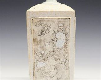 A 19th Century Japanese Edo Period Tokkuri. White porcelain Tokkuri with molded bas relief decoration consisting of two panels containing images of Shishi (foo lions) and the other two panels with motifs of dragons and tigers, with glazed flower designs accenting each panel, and scrollwork about the neck and between the panels. Unmarked. Light wear overall, areas of separation and firing cracks noted on each panel. 10 1/2" high.