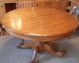 Oak dining table. Shown as round, and there is a leaf to make it oval.