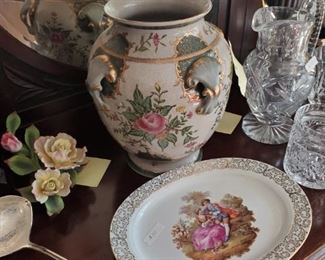 Silver serving tools, china plate, vase , crystal pitcher & decorative porcelain flowers. 