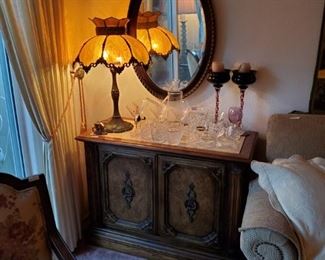 Chest, lamp, oval mirra, candle holder, crystal wine glasses.  Chair to the left & couch on right also available.