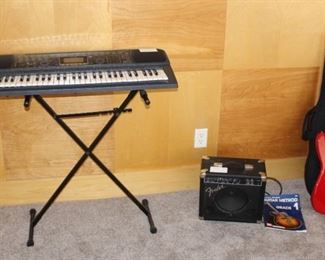 Casio piano player, small Fender speaker, Squier Stratocaster by Fender guitar.  